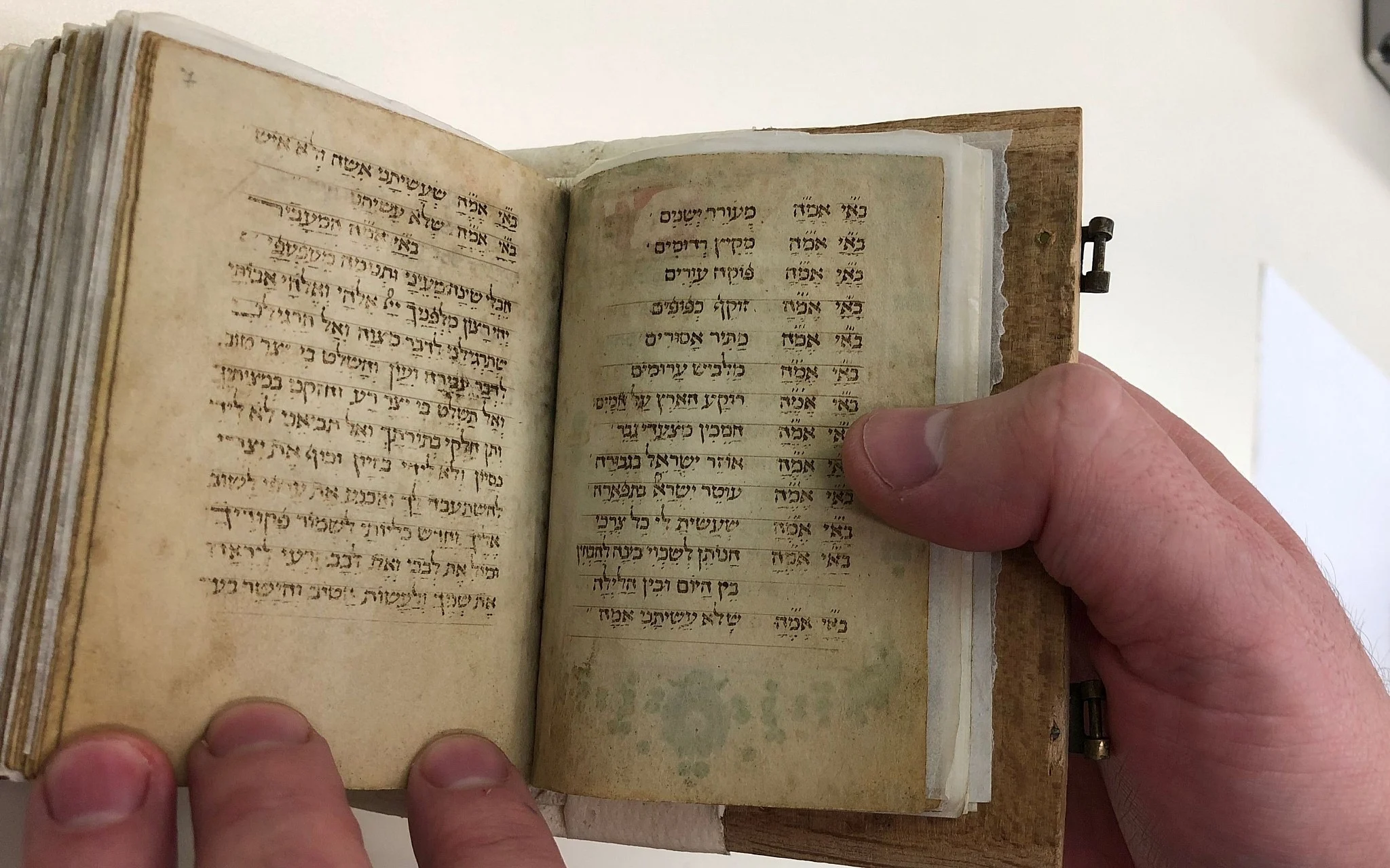 Open manuscript siddur showing the repeated morning blessings.